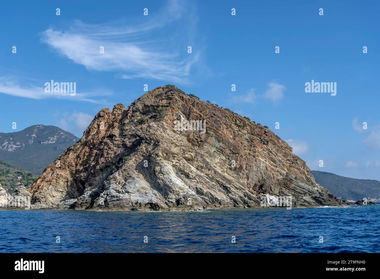 Paesaggio con isola Rossa da sud-ovest sul promontorio sulla riva mediterranea, girato da una barca alla luce dell'inizio dell'autunno ad Argentario, in Toscana, Foto Stock