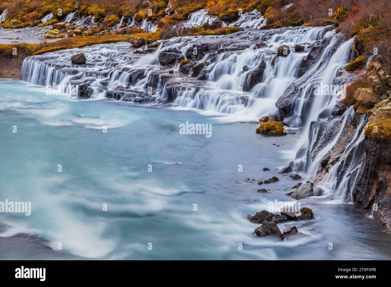 La cascata di Hraunfossar in autunno è una serie di cascate formate da rivuletti che scorrono su una distanza di circa 900 metri in Islanda, una visita da non perdere. Foto Stock