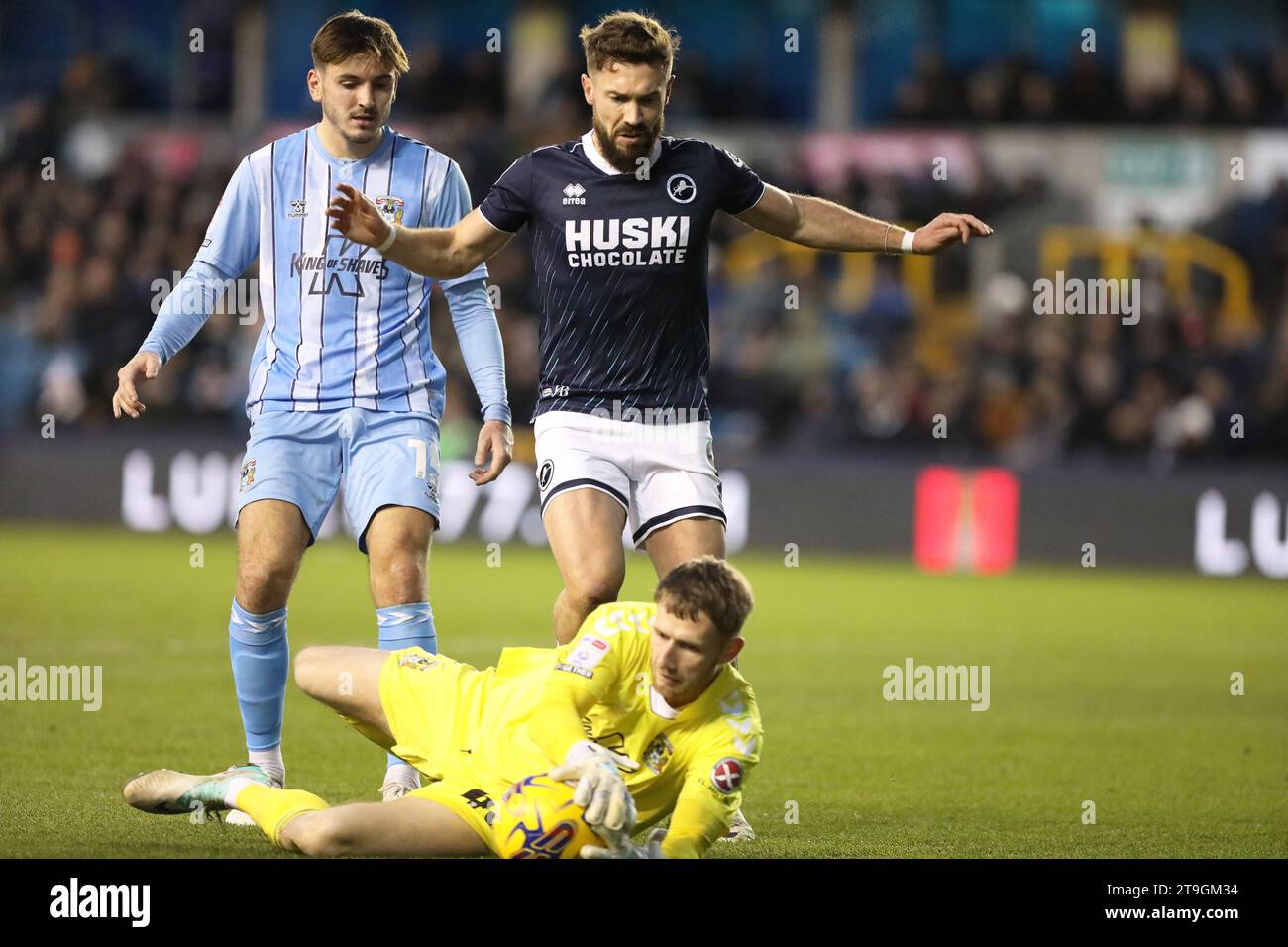 Londra, Regno Unito. 25 novembre 2023. Liam Kitching di Coventry City e Tom Bradshaw di Millwall gareggiano per il pallone durante l'EFL Sky Bet Championship match tra Millwall e Coventry City al Den, Londra, Inghilterra il 25 novembre 2023. Foto di Joshua Smith. Solo per uso editoriale, licenza necessaria per uso commerciale. Nessun utilizzo in scommesse, giochi o pubblicazioni di un singolo club/campionato/giocatore. Credito: UK Sports Pics Ltd/Alamy Live News Foto Stock