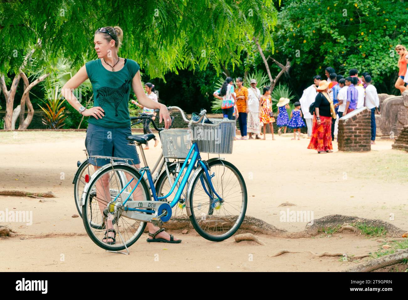 Un turista si ferma con la sua bicicletta mentre la gente del posto esplora le rovine di Polonnaruwa in Sri Lanka Foto Stock