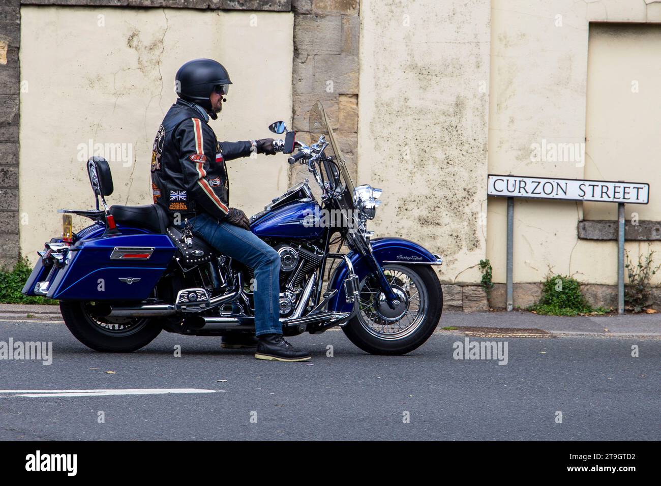 Motociclista su una moto blu Harley Davidson alla Calne bike incontra il cartello di Curzon Street sullo sfondo luglio 2023 Foto Stock