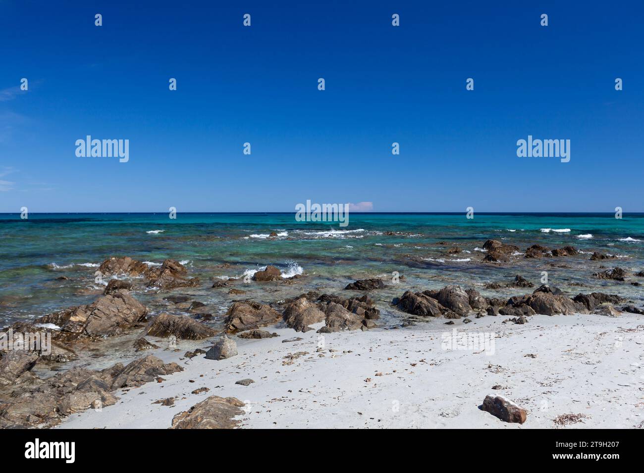 Acque turchesi cristalline del Mediterraneo e rocce costiere in Sardegna, Italia, in una giornata di sole. Il mare è bellissimo. Foto Stock