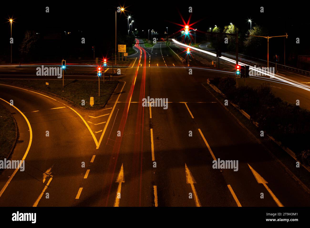 Lunga esposizione di traffico notturno presa dall'alto sul ponte che si affaccia sulla A38 vicino a Ikea a Exeter, Regno Unito Foto Stock