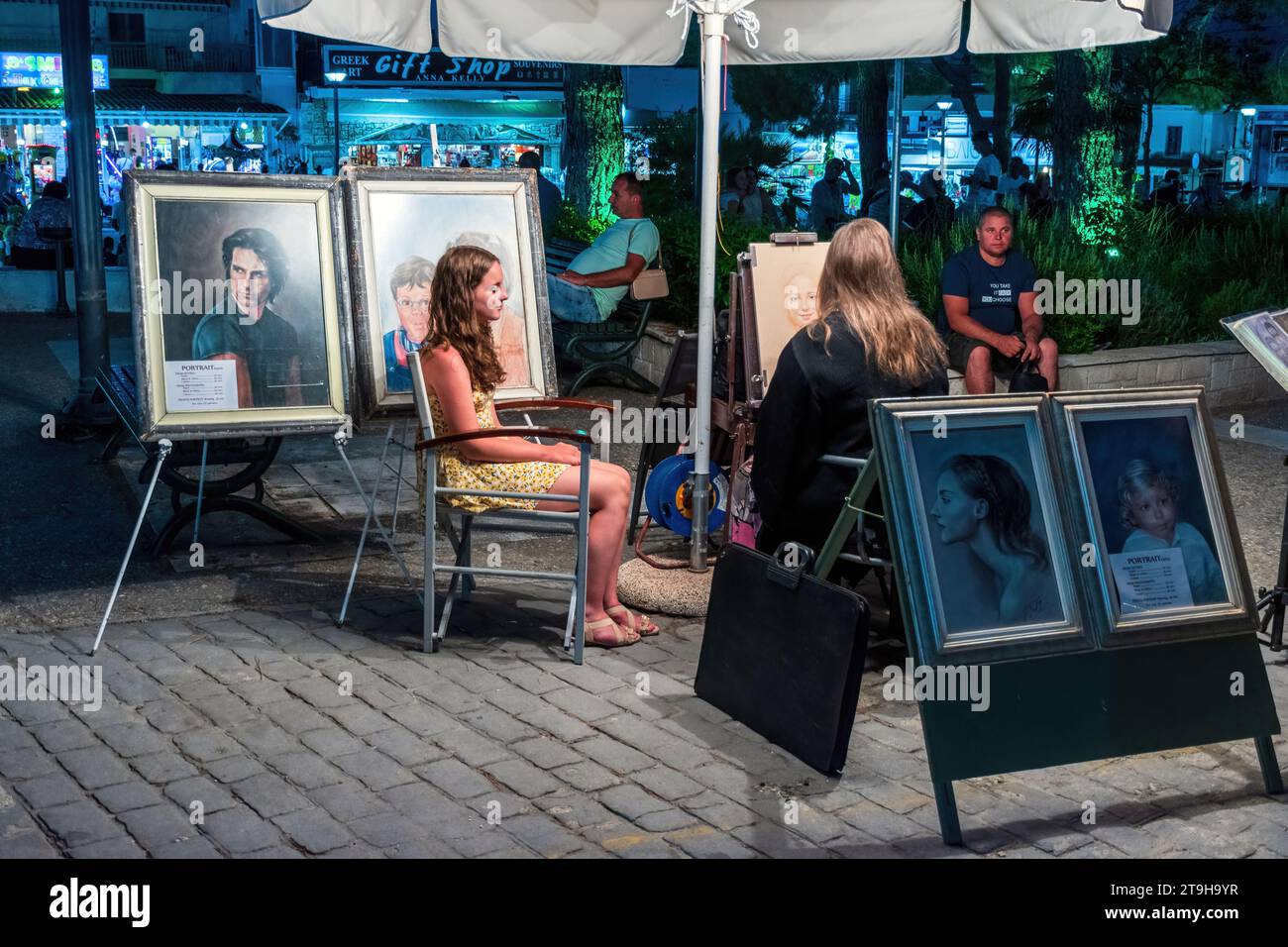 Una donna artista di strada dipinge un ritratto di una ragazza. Chaniotis, Grecia Foto Stock