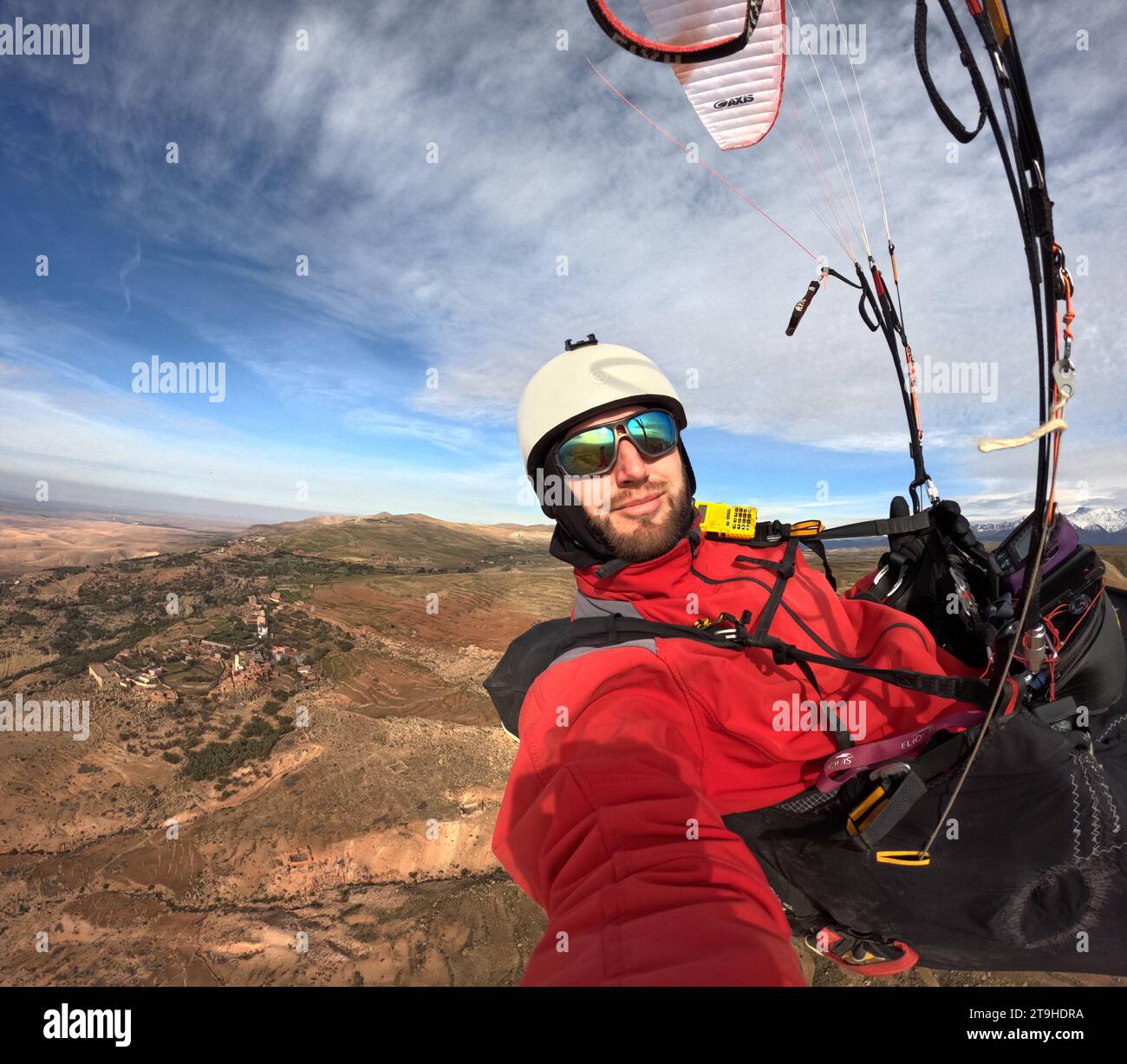 Selfie di parapendio, selfie di un pilota di parapendio che vola in alto tra le nuvole sopra le montagne con la sua ala di parapendio Foto Stock