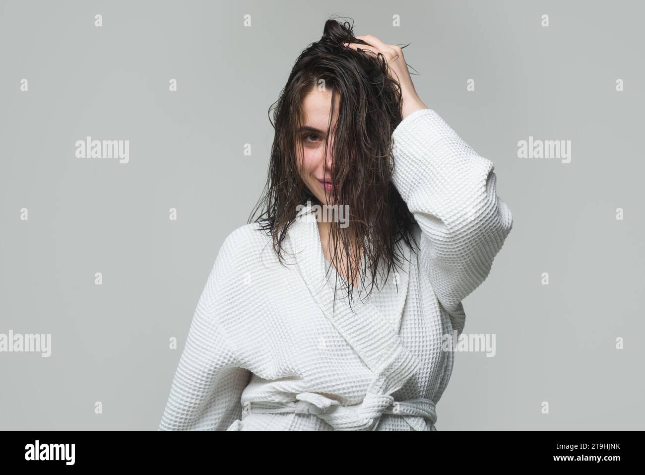 Giovane donna bruna dai capelli lunghi nutriti, ripresa in studio. Ragazza che si tocca i capelli Foto Stock