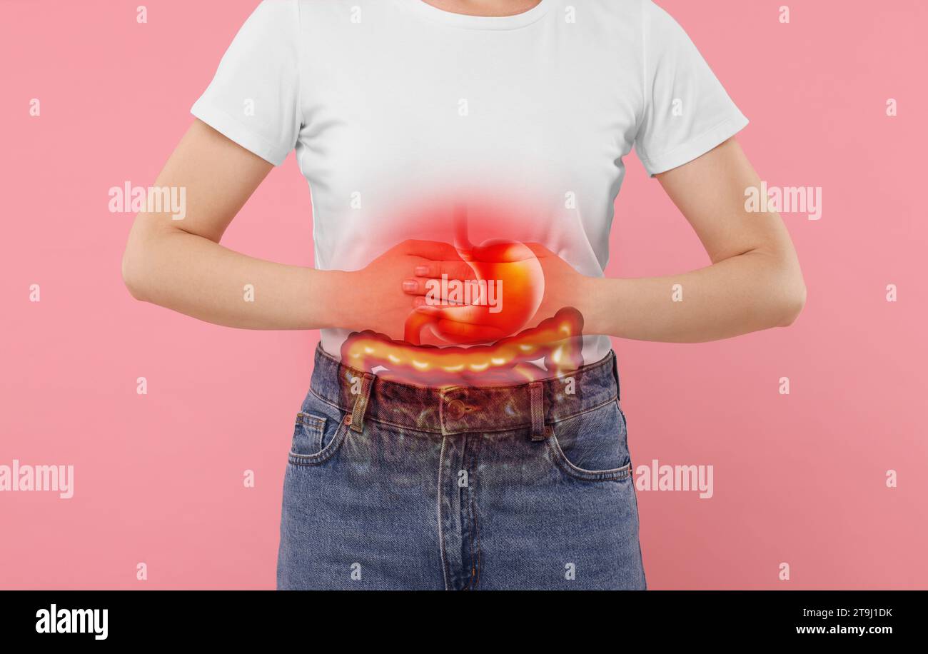 Donna che soffre di mal di stomaco su sfondo rosa, primo piano. Illustrazione del tratto gastrointestinale malsano Foto Stock