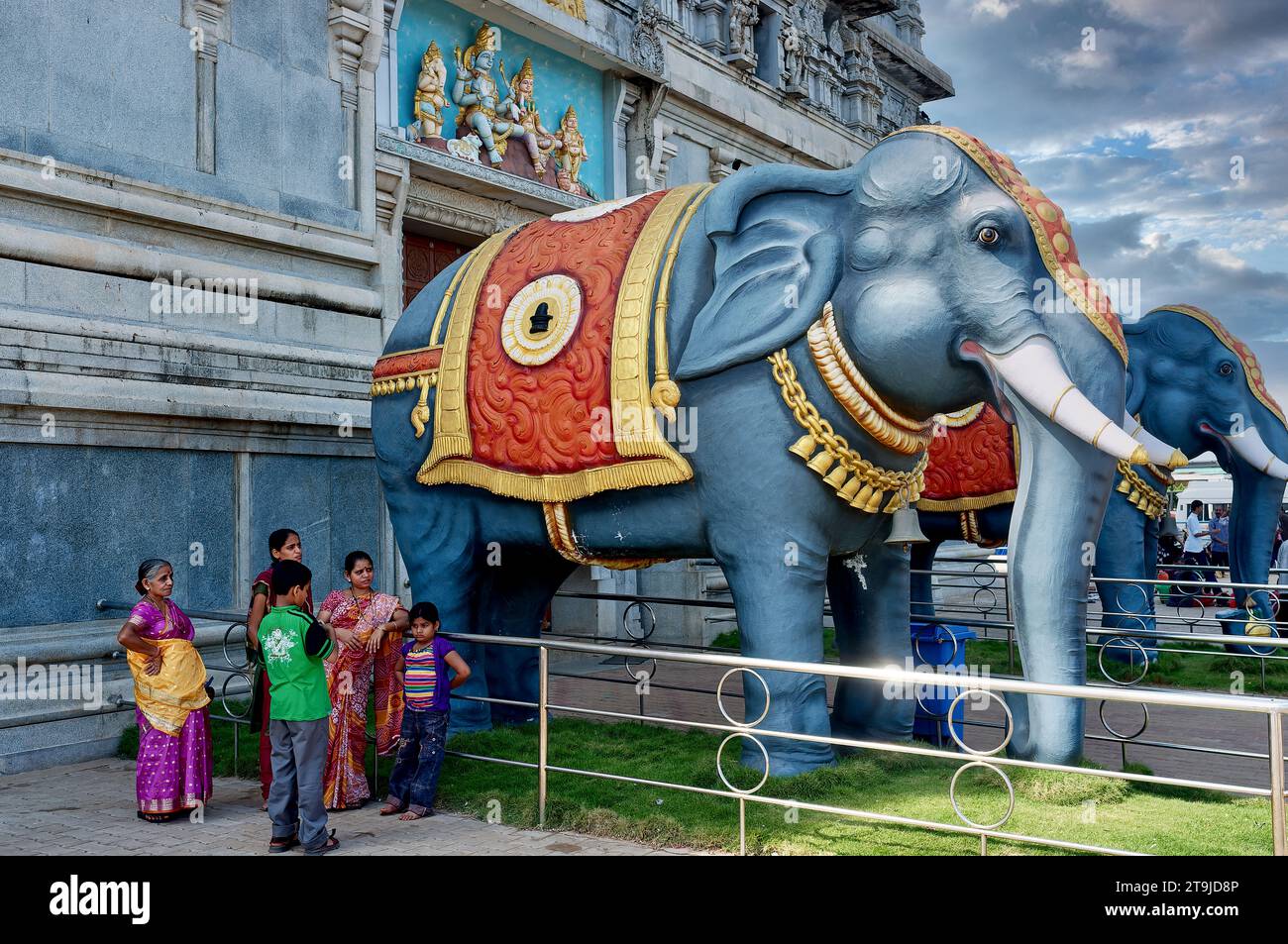 I turisti si trovano accanto a due statue di elefanti a guardia dell'ingresso al tempio Murdeshwara (Murudeshwara) a Murdeshwar, Karnataka, India. Foto Stock