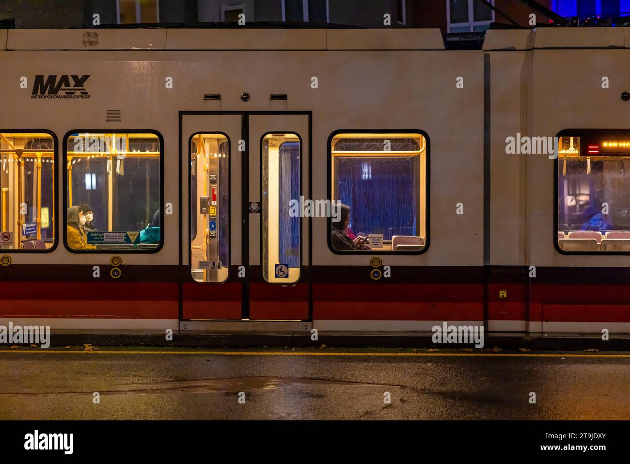 Persone che viaggiano sul treno MAX Light Rail in una notte di pioggia a Portland, Oregon, Stati Uniti {nessun rilascio di modelli; solo licenze editoriali] Foto Stock