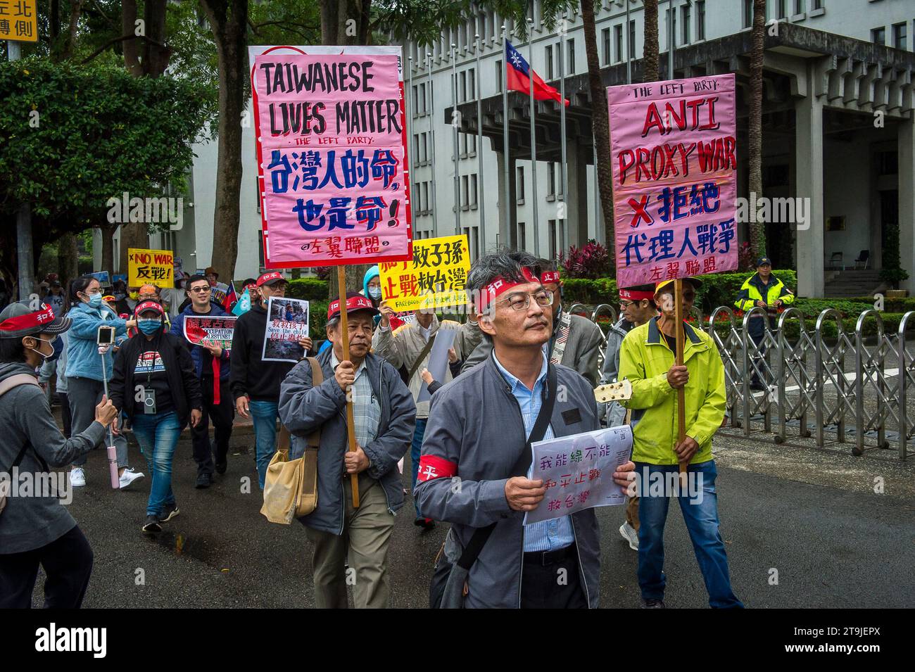 I manifestanti marciano lungo Zhongshan South Road vicino a Liberty Square, President Office e Ministero degli affari Esteri a Taipei, Taiwan, il 26/11/2023, esprimendo la loro opposizione alle estensioni militari della coscrizione, ai profitti di guerra e alle corse di armi, e sostenendo i colloqui di pace tra Taiwan e Cina. La protesta, organizzata dalla piattaforma per la pace e l'anti-guerra, dal governo parallelo, dall'Alleanza di sinistra e dal Think Tank Hae Tide, evidenzia le preoccupazioni dell'opinione pubblica sulla posizione geopolitica di Taiwan e sui potenziali rischi di un'escalation delle tensioni nello stretto di Taiwan. I partecipanti, holdin Foto Stock