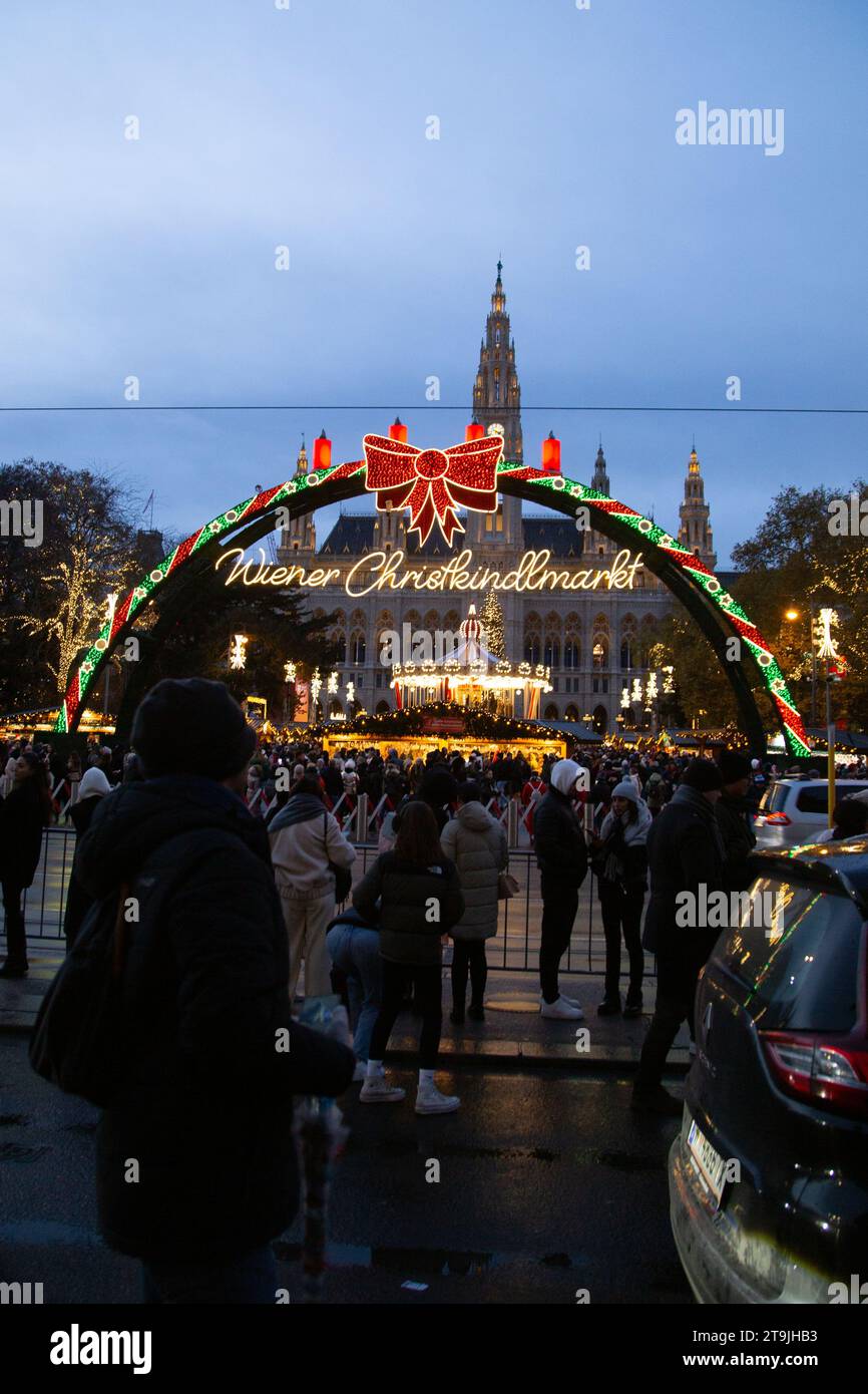 Ingresso all'affollato mercatino di Natale (Wiener Christkindlmarkt) durante la notte invernale a Rathause, Vienna, Austria Foto Stock