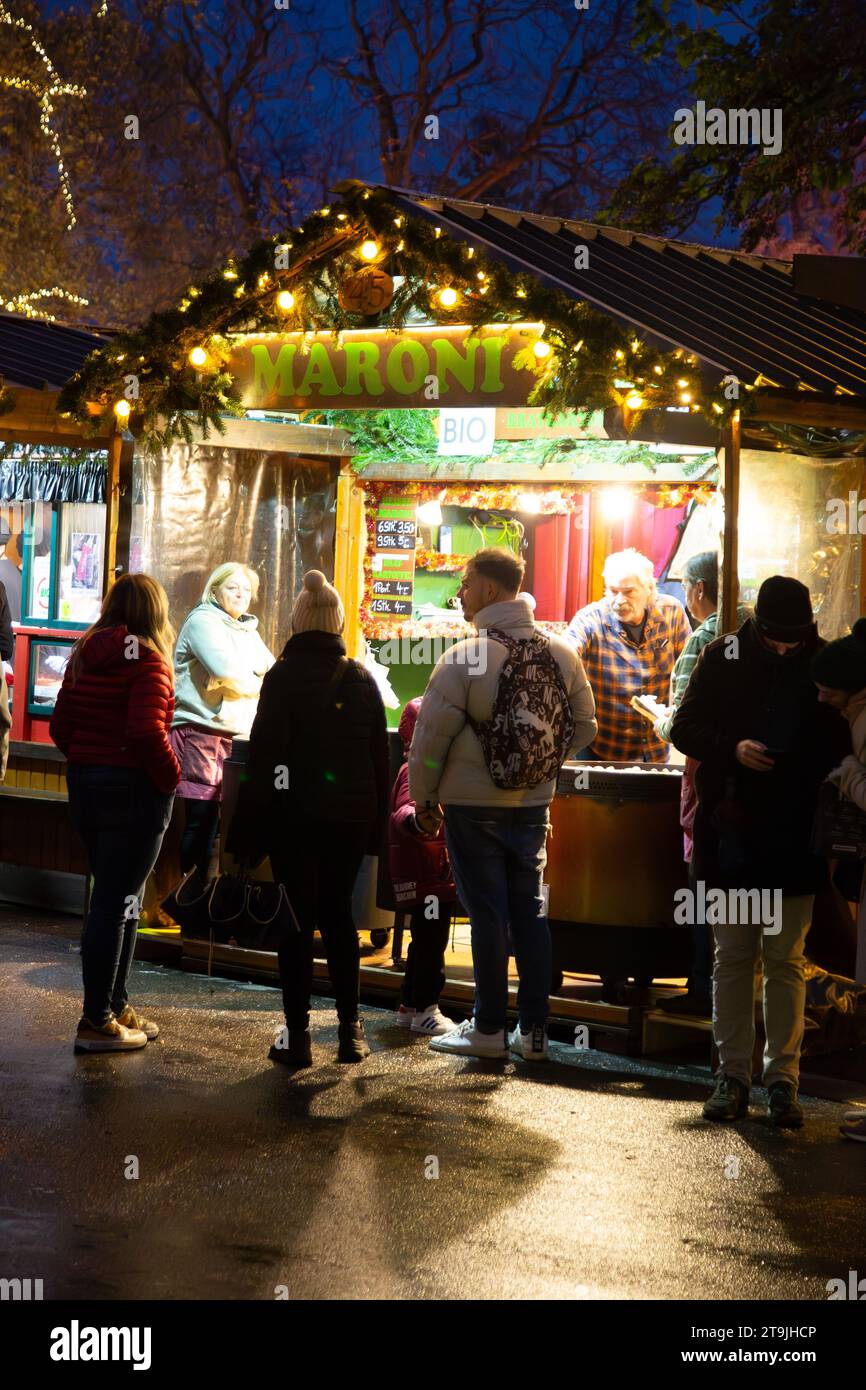 Un locale di Street food affollato di visitatori al mercatino di Natale (Wiener Christkindlmarkt) di notte in inverno, Rathause, Vienna, Austria Foto Stock