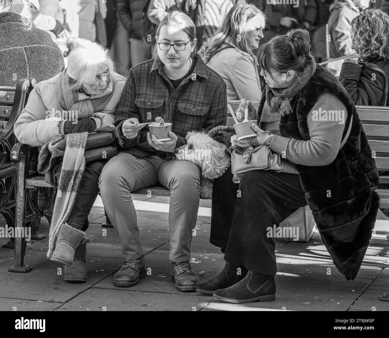 Gente che mangia su una panchina Foto Stock