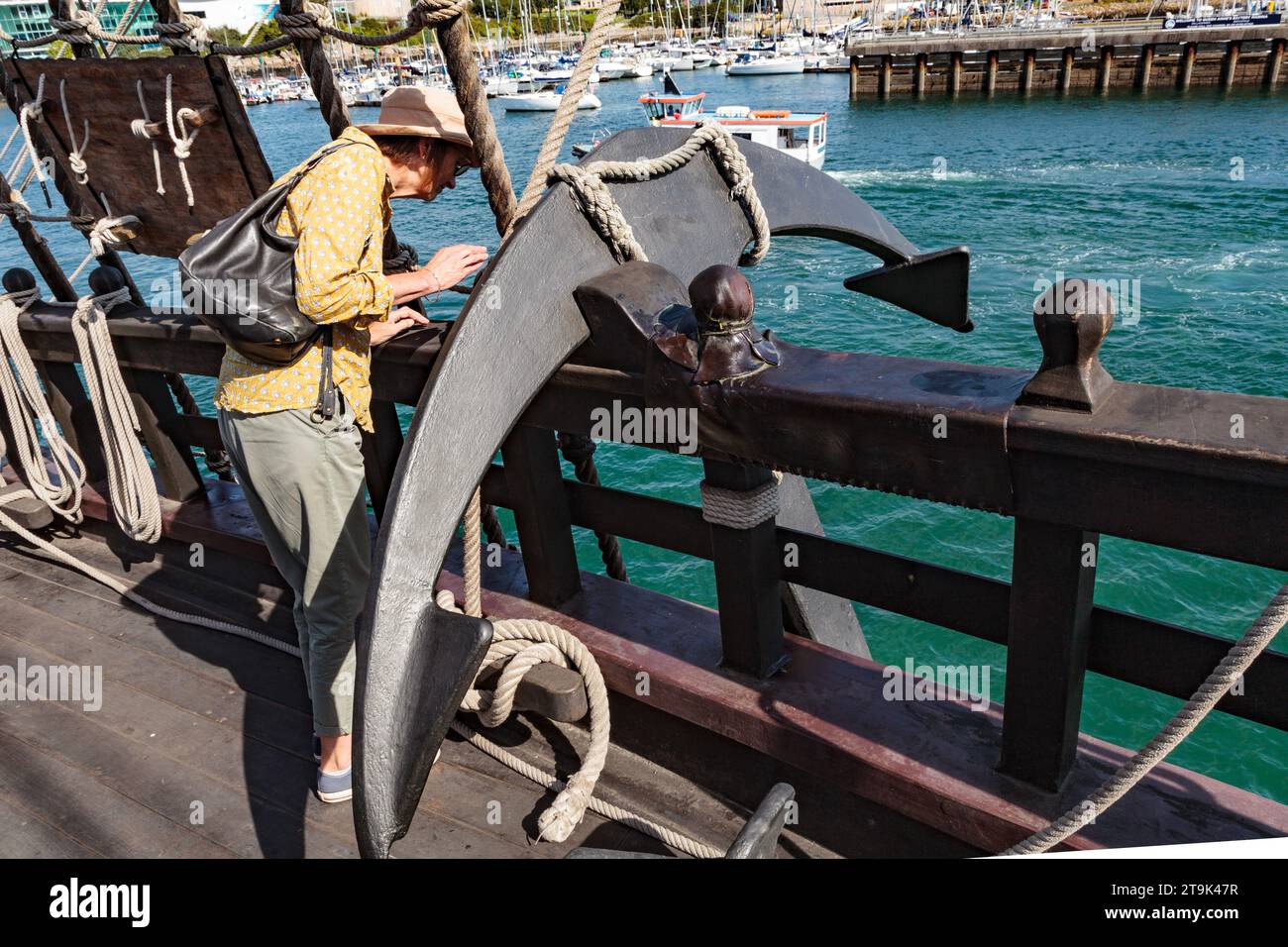 El Galeon Andalucía: Plymouth Barbican 2023. Replica completa e perfettamente funzionante di un galeone del XVI - XVII secolo. Donna vicino all'ancora della nave Foto Stock