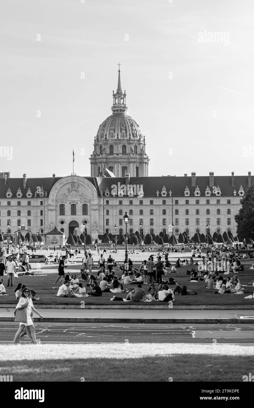 Parigi, Francia - 8 ottobre 2023: Veduta della folla di giovani seduti in piccoli gruppi in un parco verde di fronte all'Hotel des Invalides Foto Stock