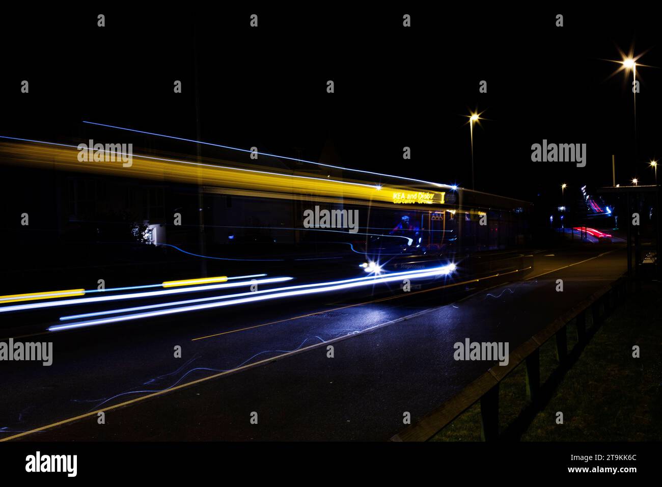 Lunga esposizione di un autobus locale di Exeter che parte di notte Foto Stock