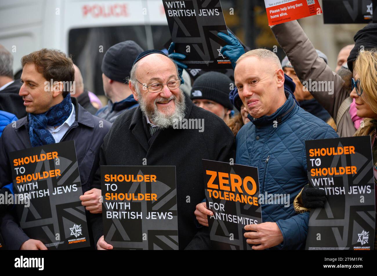 Migliaia di persone marciano contro l'antisemitismo a Londra, con figure di spicco che guidano la marcia, tra cui il rabbino capo e molti attori. Un uomo ha arrestato e messo in furgone della polizia. Foto Stock