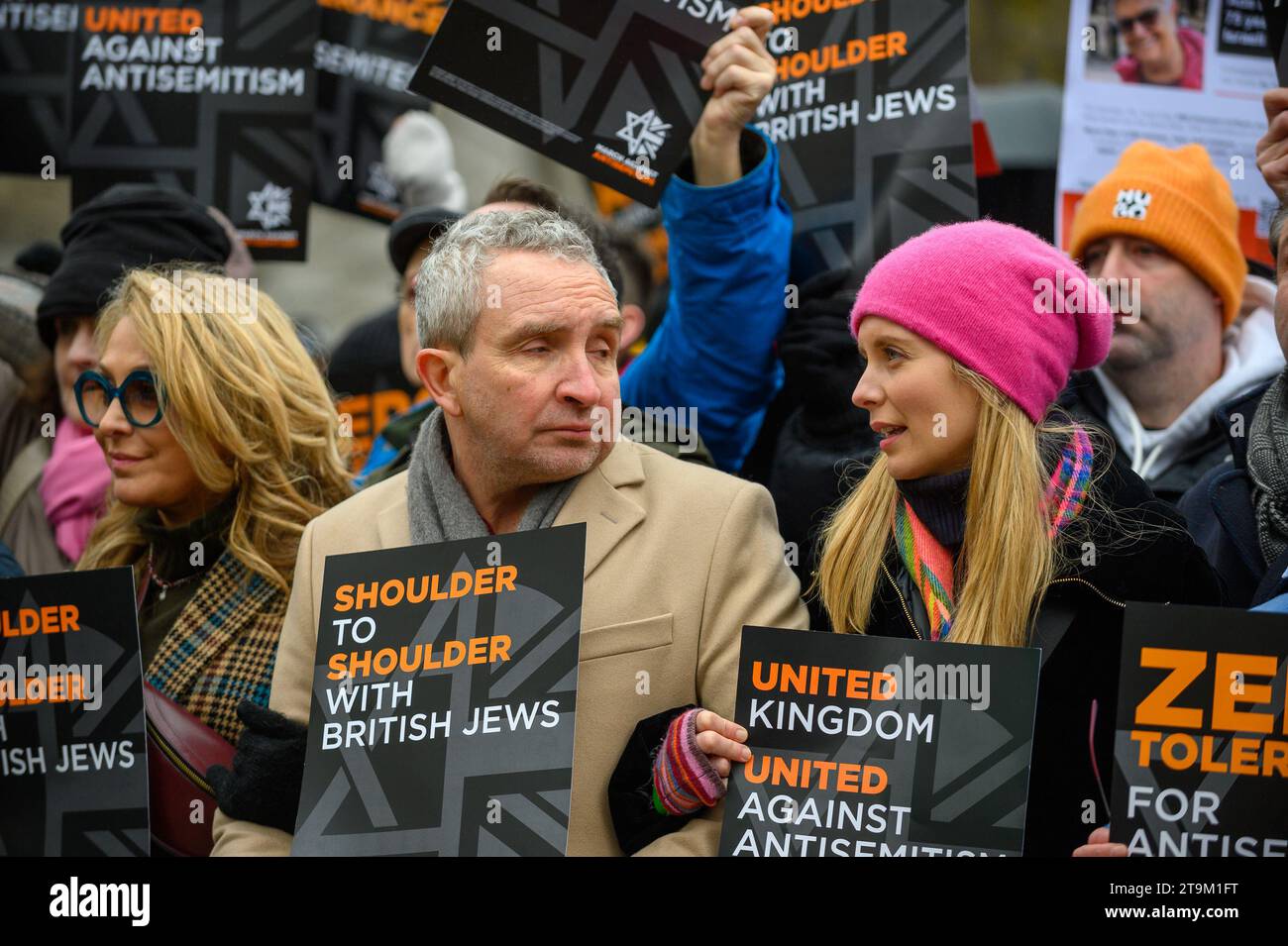 Migliaia di persone marciano contro l'antisemitismo a Londra, con figure di spicco che guidano la marcia, tra cui il rabbino capo e molti attori. Un uomo ha arrestato e messo in furgone della polizia. Foto Stock