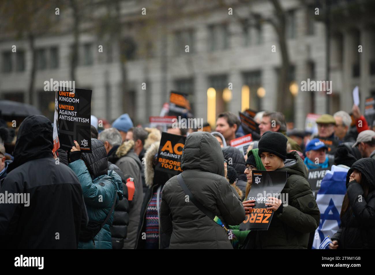 Migliaia di persone marciano contro l'antisemitismo a Londra, con figure di spicco che guidano la marcia, tra cui il rabbino capo e molti attori. Un uomo ha arrestato e messo in furgone della polizia. Foto Stock