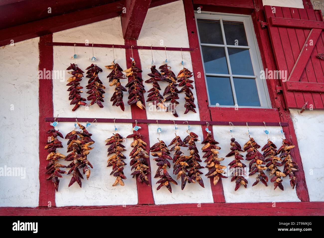 Piments d'espelette Sechant au soleil sur une faade d'une maison du Pays basque Foto Stock