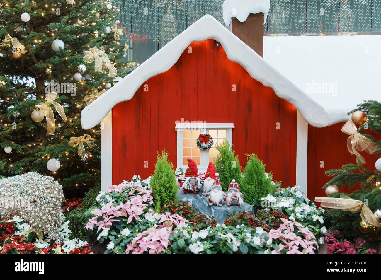 Una vivace scena natalizia con una casa decorata con decorazioni festive e illuminata da luci colorate Foto Stock