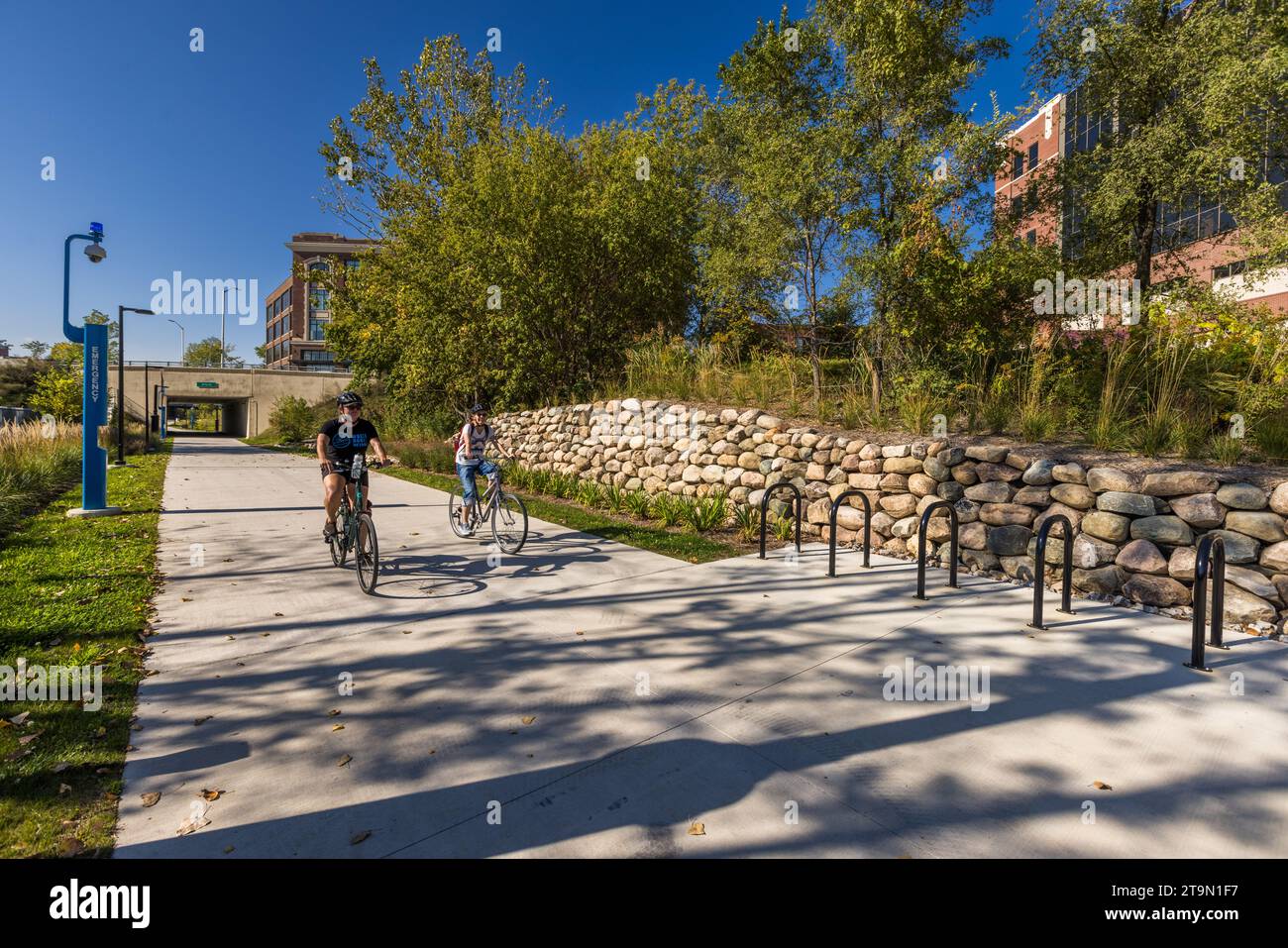 Tour guidato in bicicletta nel centro di Detroit. I vecchi binari ferroviari sono stati convertiti in percorsi multiuso per pedoni e ciclisti. Oggi, le generose piste ciclabili ci ricordano che Detroit era un centro dell'industria ciclistica americana prima che diventasse un simbolo di una città automobilistica. Detroit, Stati Uniti Foto Stock