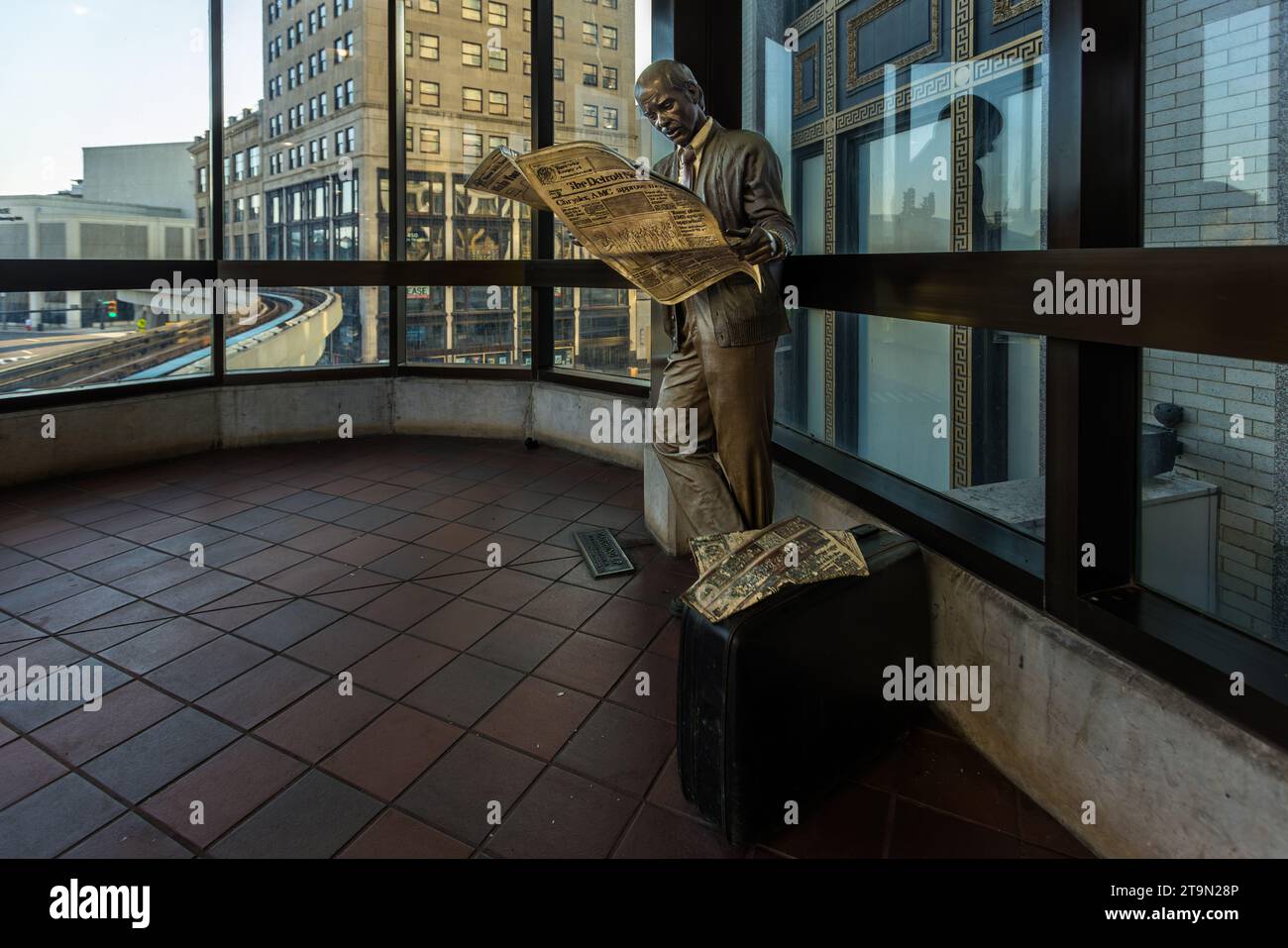 Stazione del circuito People Mover nel centro di Detroit. L'accesso al treno sopraelevato completamente automatizzato è possibile inserendo una moneta da un quarto di dollaro nelle macchine di ogni stazione. Scultura nella stazione Grand Circus Park del Peoplemover a Detroit, Stati Uniti. "Catching Up" dell'artista J. Seward Johnson mostra un uomo che legge l'edizione di Detroit News del 21 maggio 1987 Foto Stock