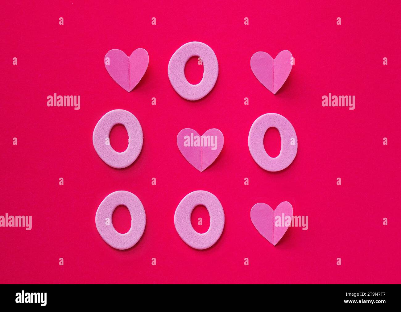 TIC tac TOE fatto di cuori e zeri su sfondo rosa. L'amore vince sempre il concetto. Spianatura piatta. Valentine o il concetto d'amore. Foto Stock
