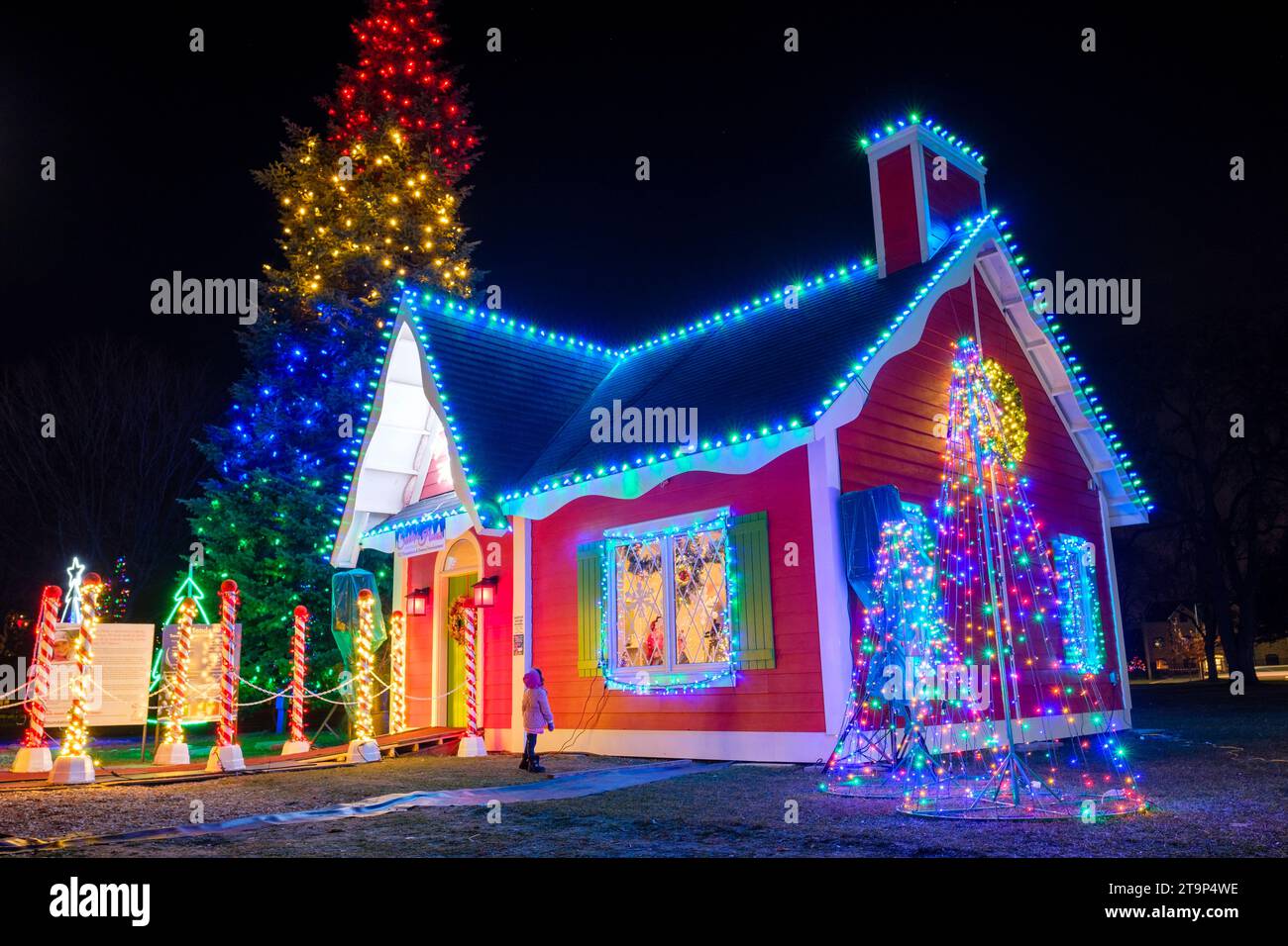 Decorazioni natalizie, scena natalizia, bambino fuori casa di Babbo Natale, giorno di Natale, albero di Natale all'aperto con luci natalizie Foto Stock