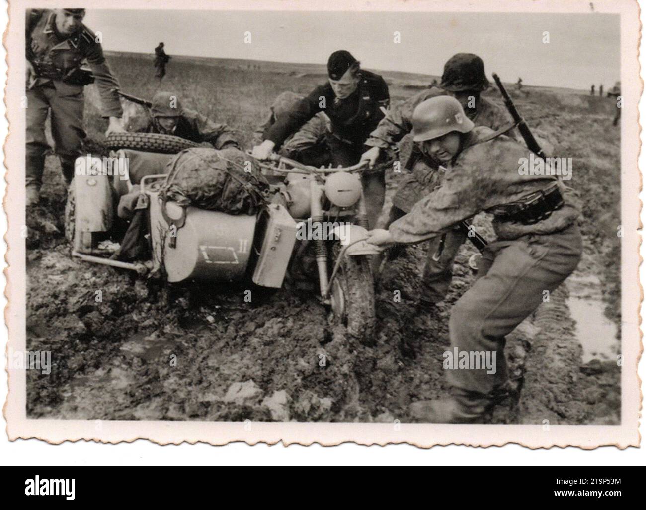 World War Two B&W foto . I soldati tedeschi della 5th SS Panzer Division Wiking spingono una motocicletta e una Sidecar attraverso il fango in Polonia 1944 Foto Stock