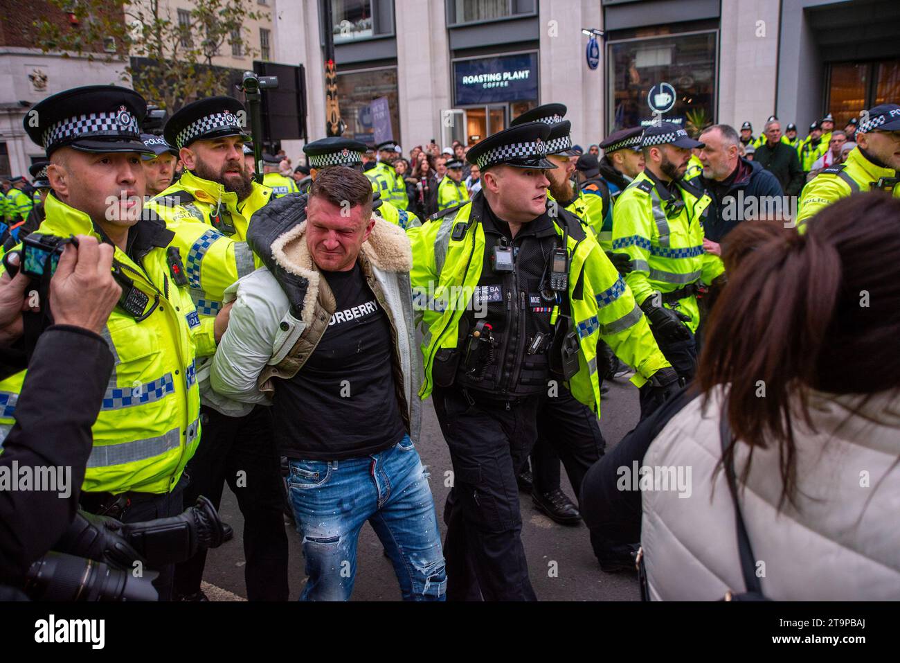 Londra, Regno Unito. 26 novembre 2023. Gli agenti di polizia arrestano il fondatore di estrema destra della English Defence League Tommy Robinson fuori dalla Corte reale di giustizia di Londra durante la marcia. Decine di migliaia di persone hanno marciato attraverso il centro di Londra dalla Corte reale di giustizia alla Piazza del Parlamento durante la manifestazione contro l'antisemitismo. Secondo l'Unione europea, l'antisemitismo sta aumentando rapidamente da quando la guerra Israele-Hamas è iniziata il 7 ottobre. (Foto di Krisztian Elek/SOPA Images/Sipa USA) credito: SIPA USA/Alamy Live News Foto Stock