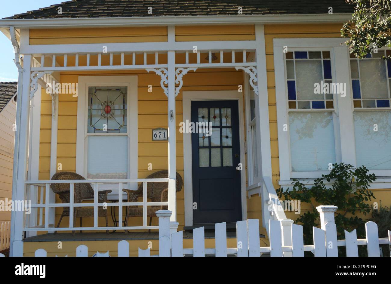 Affascinante cottage giallo in stile vittoriano con una recinzione a picchetto bianca e invitante veranda frontale, Pacific Grove, CALIFORNIA. Foto Stock