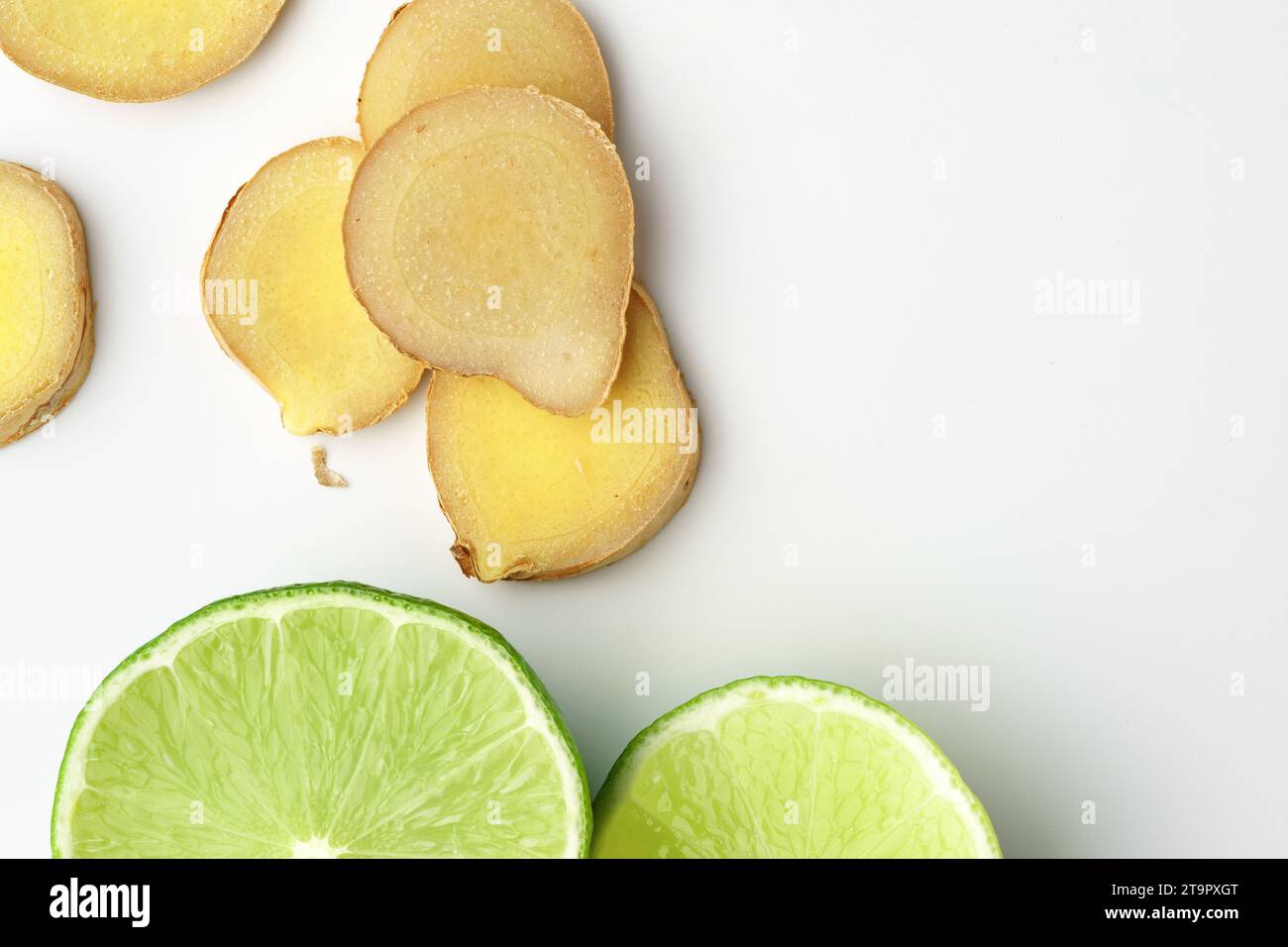 Fette di lime e zenzero su sfondo bianco Foto Stock