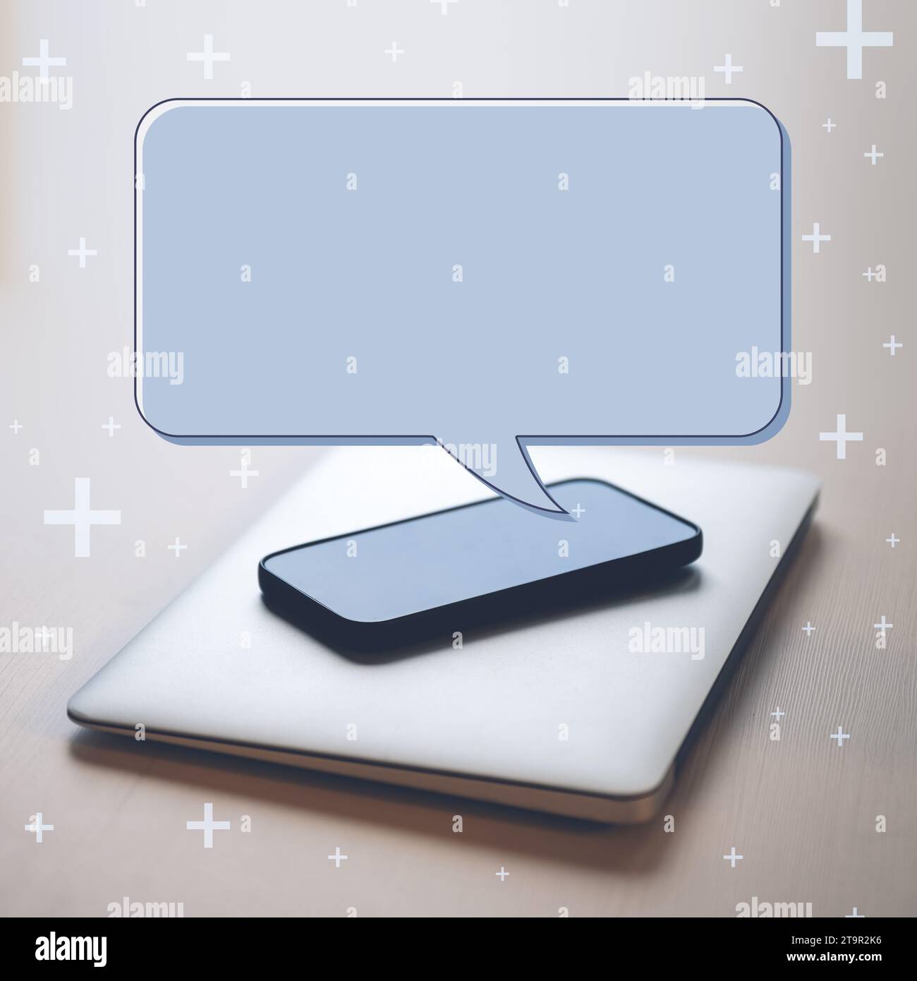 Spazio di copia per il mockup delle bolle vocali dei social media sullo smartphone posizionato sul computer portatile alla scrivania dell'ufficio, messa a fuoco selettiva Foto Stock