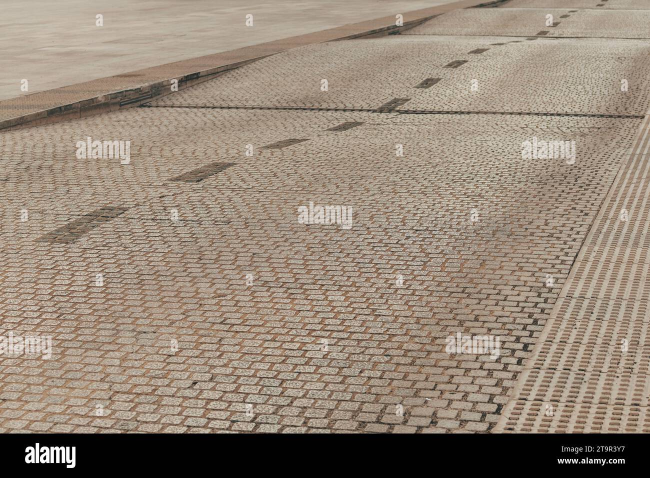 Strada ondulata pavimentata con blocchi di pietra, messa a fuoco selettiva Foto Stock