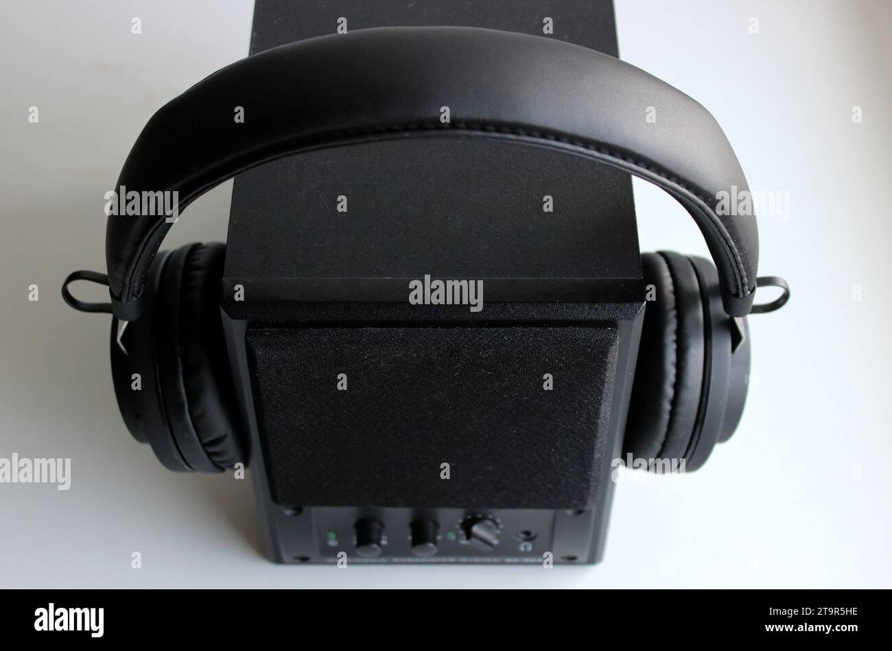 Altoparlante audio in legno nero con cuffie wireless isolate sulla vista superiore bianca Foto Stock