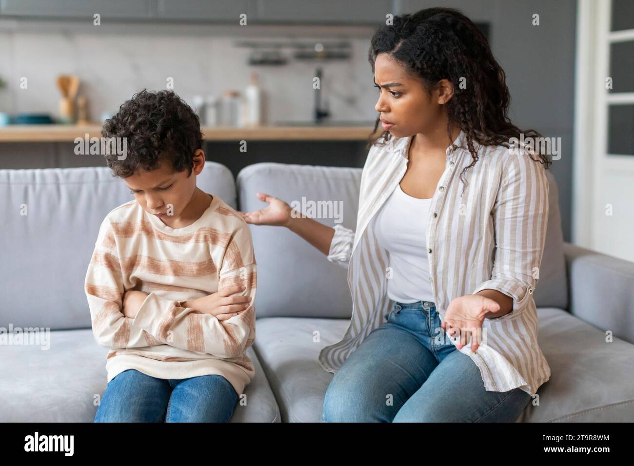 Una madre afroamericana arrabbiata che rimprovera piccolo figlio a casa Foto Stock