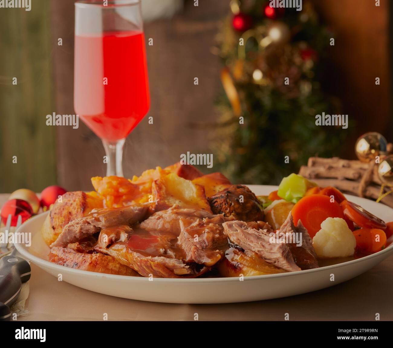 Cena di tacchino di Natale con decorazioni e un bicchiere di vino rosso. Foto Stock