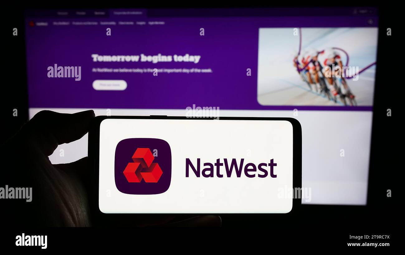 Persona che possiede un telefono cellulare con il logo della società finanziaria National Westminster Bank (NatWest) davanti alla pagina Web. Concentrarsi sul display del telefono. Foto Stock
