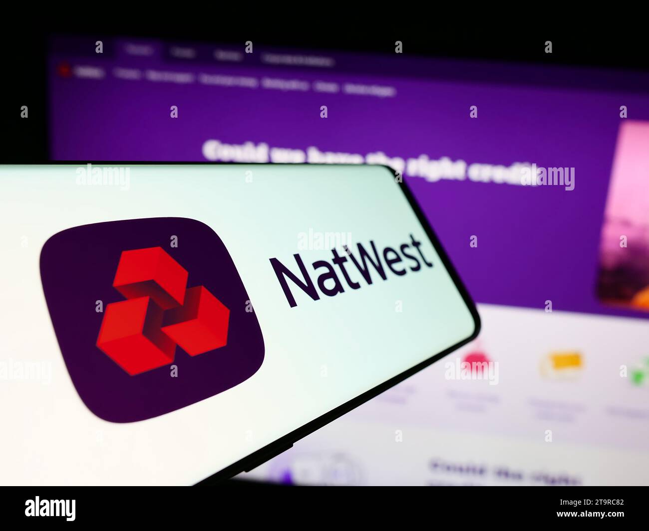 Cellulare con logo della società finanziaria National Westminster Bank (NatWest) davanti al sito Web aziendale. Mettere a fuoco il display centrale sinistro del telefono. Foto Stock