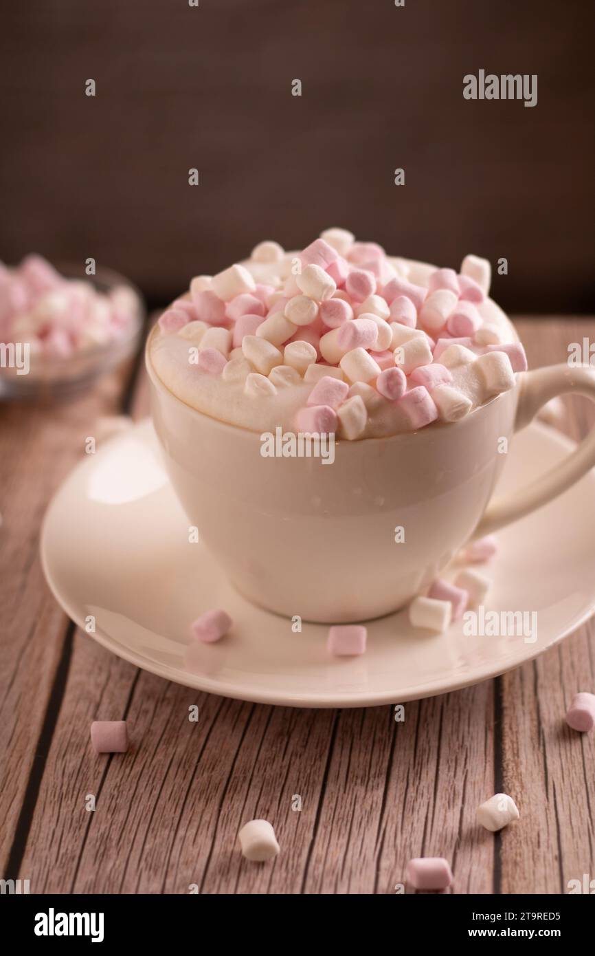 dolce dolce fotografico, marshmallow bianco e rosa si trova in una tazza di caffè con schiuma, primo piano, piacere, minimalismo, spuntino, caffè, atmosfera Foto Stock