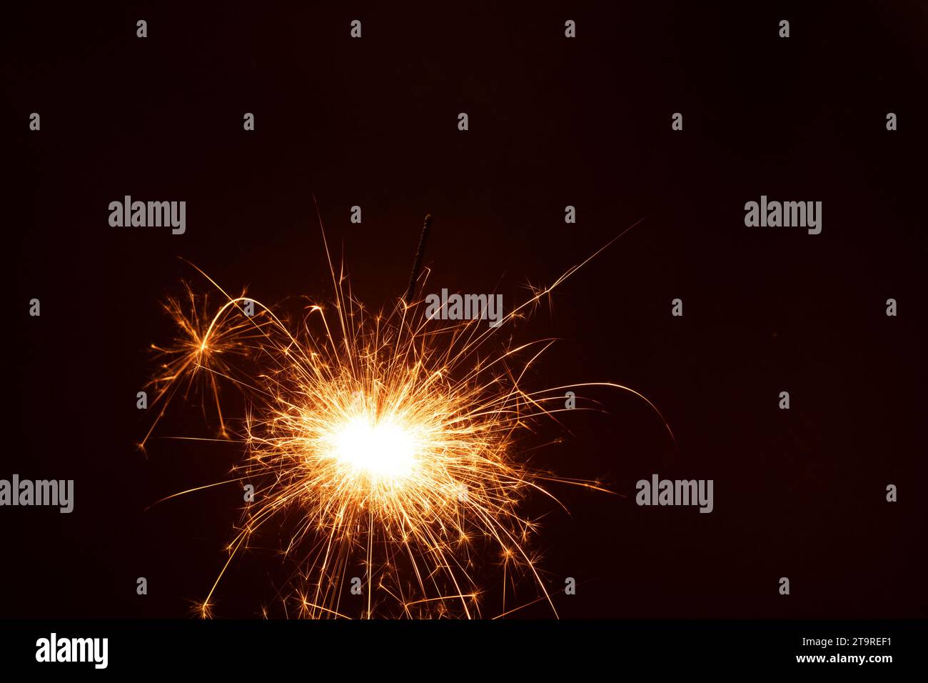 Foto un singolo sparkler illumina la scena, irradiando una calda luce in questa foto natalizia. Perfetto per festeggiamenti e feste, il Foto Stock