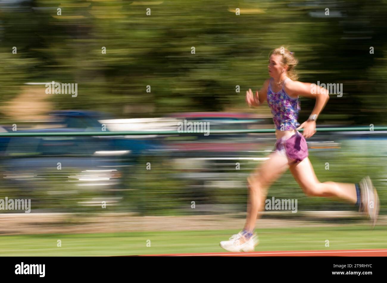 Una donna che corre in pista a Fort Collins, Colorado. (movimento sfocato) Foto Stock