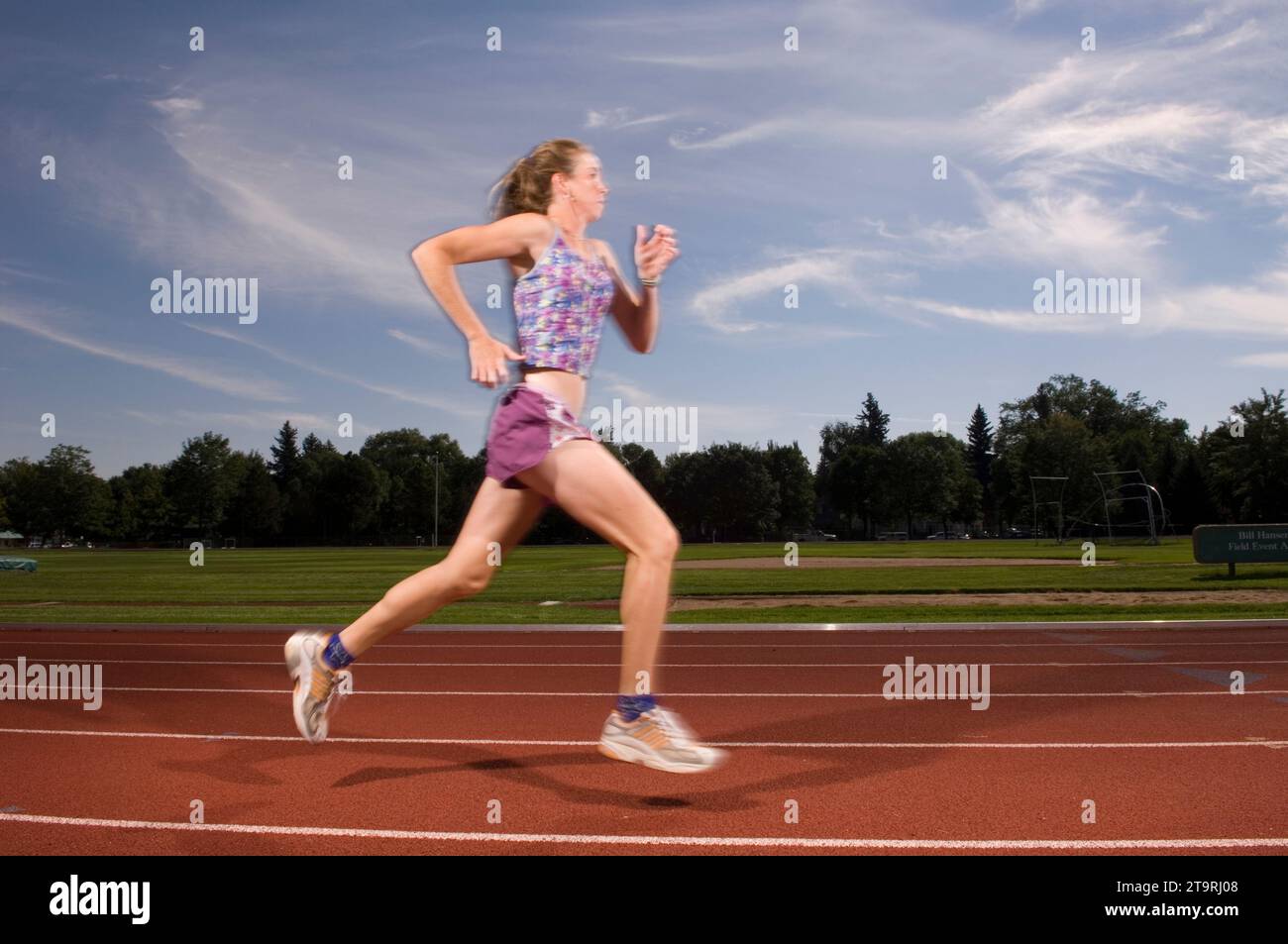 Una donna che corre su una pista a Fort Collins, Colorado. (movimento sfocato) Foto Stock