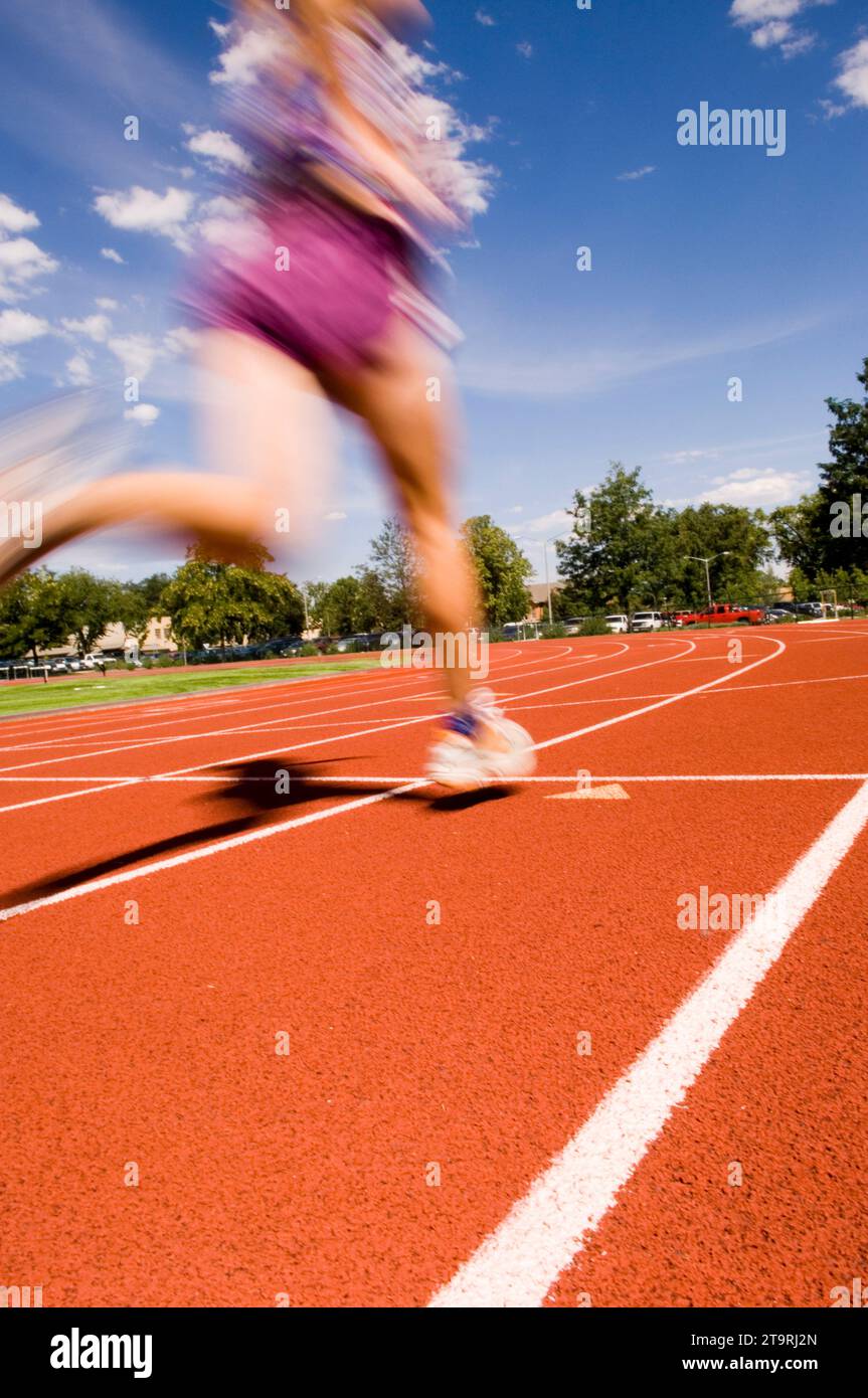 Una donna che corre su una pista a Fort Collins, Colorado. (movimento sfocato) Foto Stock