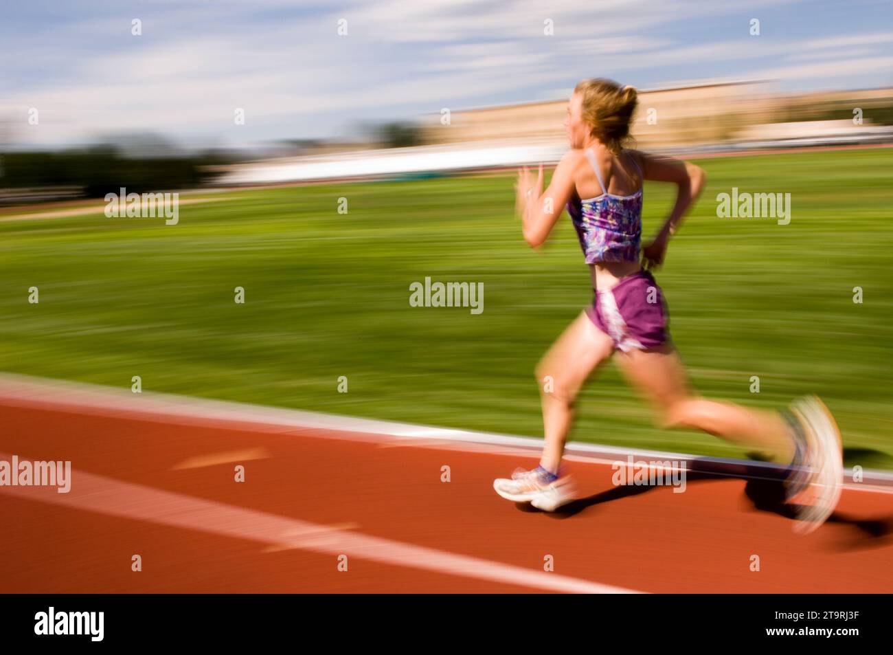 Una donna che corre in pista a Fort Collins, Colorado. (movimento sfocato) Foto Stock