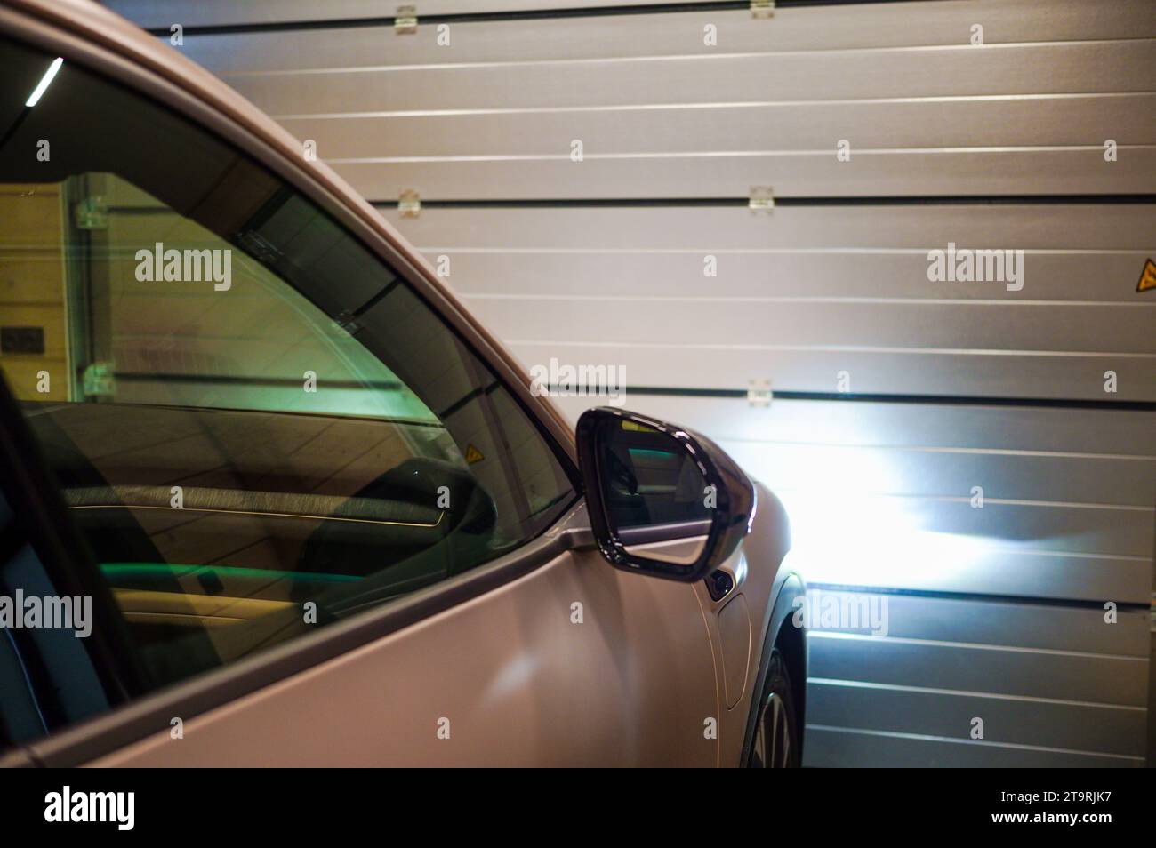 un'auto davanti alle porte di garage a rulli in metallo Foto Stock