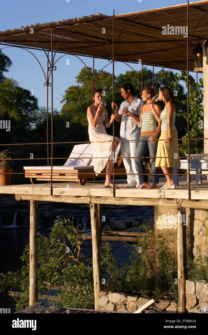 Amici che bevono su un ponte a Carmelo, in Uruguay. Foto Stock
