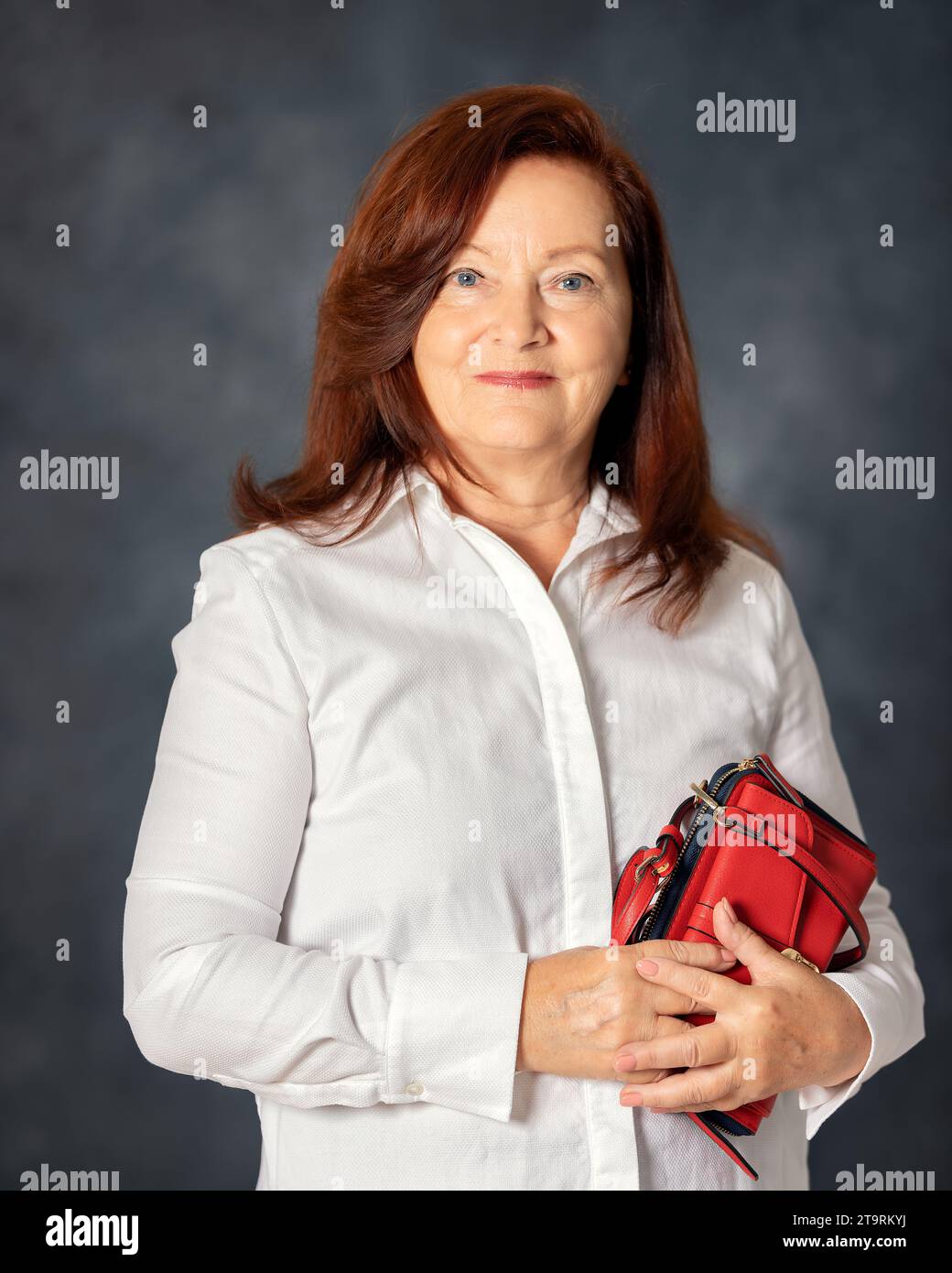 Ritratto di elegante donna di 60s anni su sfondo grigio. Donna matura di mezza età, elegante e sicura in europa Foto Stock