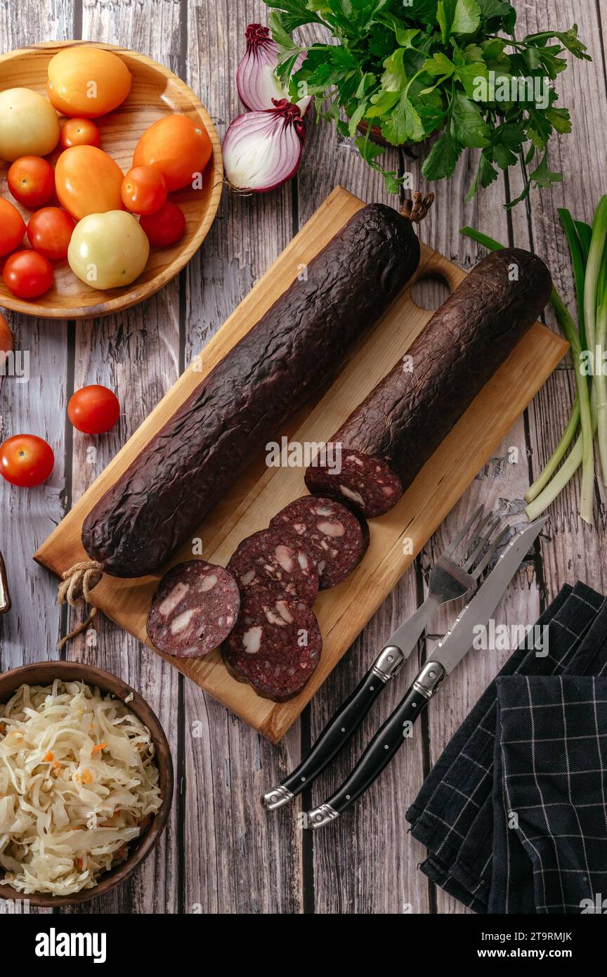 Salsiccia di maiale affumicata su tagliere di legno e tessuto di iuta. Foto Stock